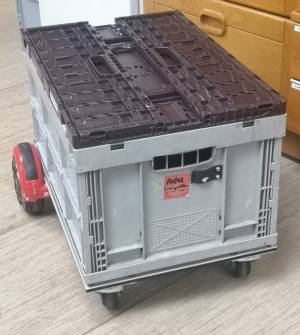 Das Hoverboard mit einer 60x40x28 cm Euro-Klappbox drauf, darauf eine weitere, flachere, zusammengeklappte Klappbox als Deckel