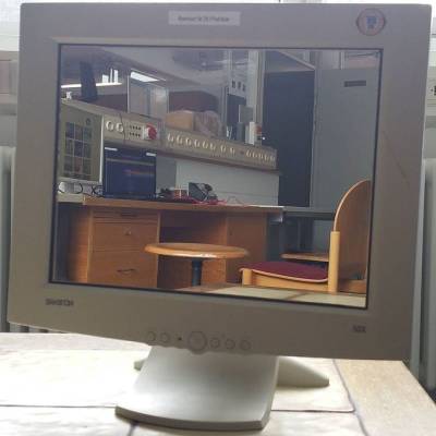 Bildschirm mit aufgeklebtem Spiegel im Fachschaftsraum, im Spiegel ist die Computerecke zu sehen, hinter dem Monitor ein Fenster mit Heizkörper darunter. Bildschirm mit aufgeklebtem Spiegel im Fachschaftsraum, im Spiegel ist die Computerecke zu sehen, hinter dem Monitor ein Fenster mit Heizkörper darunter.